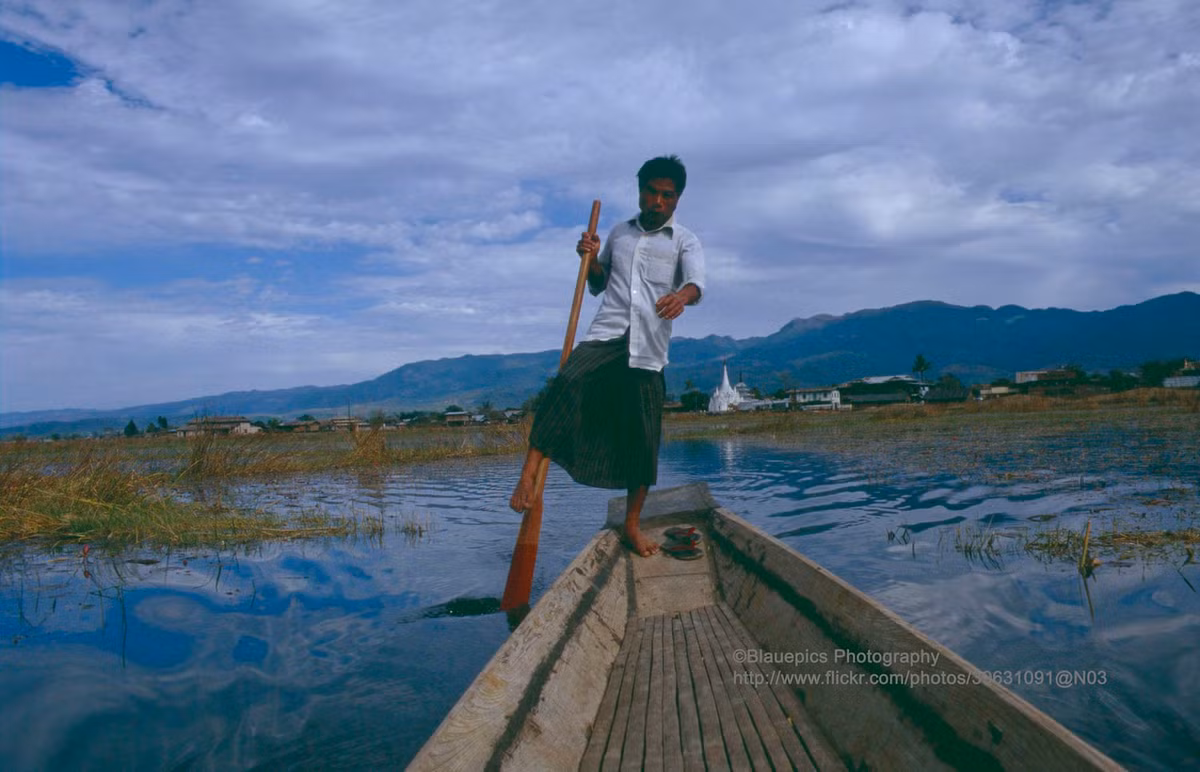 Ngư dân đứng một chân trên thuyền gỗ nhỏ - kiểu di chuyển và đánh bắt cá truyền thống ở hồ Inle.