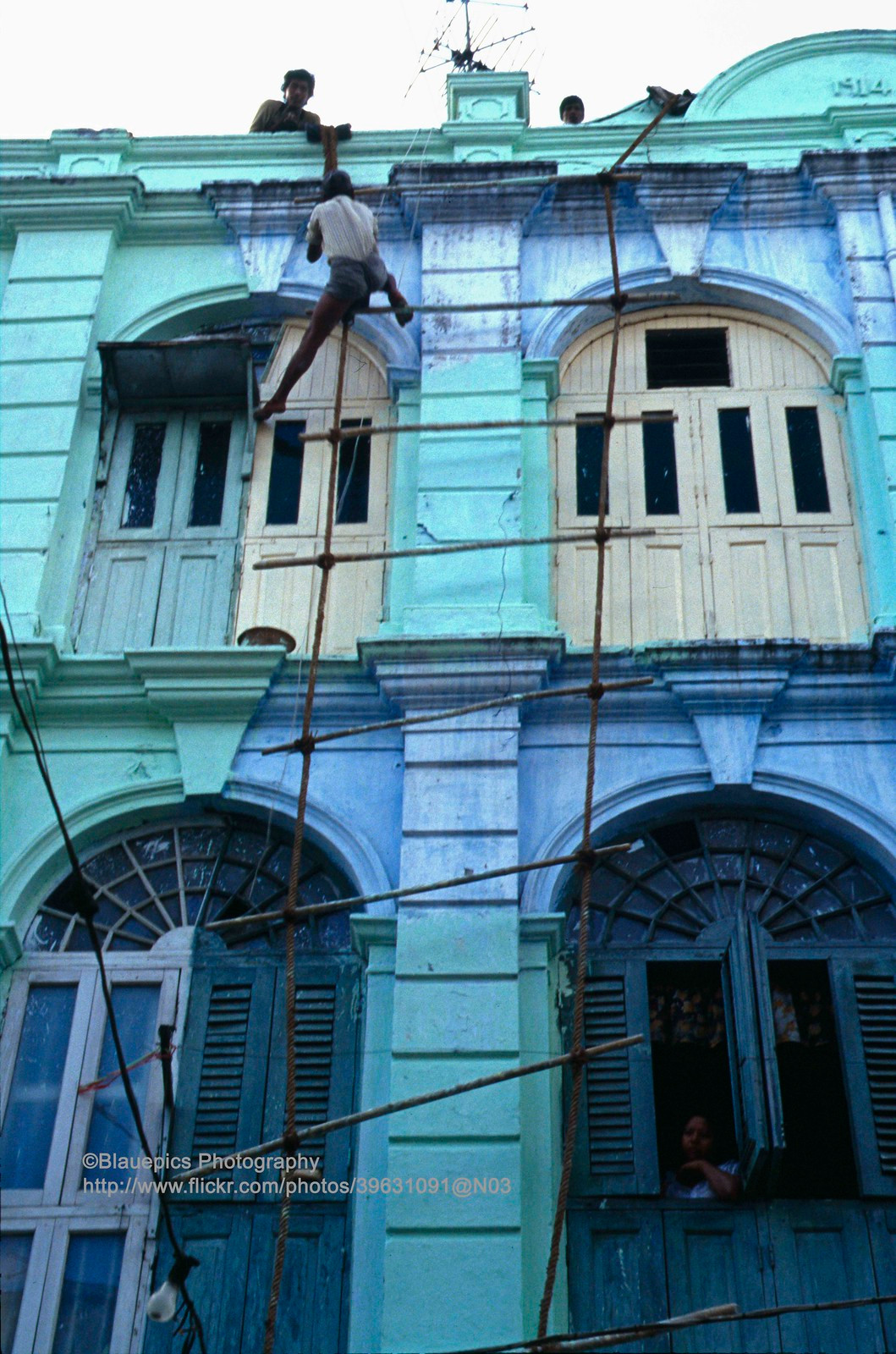 Thợ xây làm việc trên dàn giáo thô sơ.