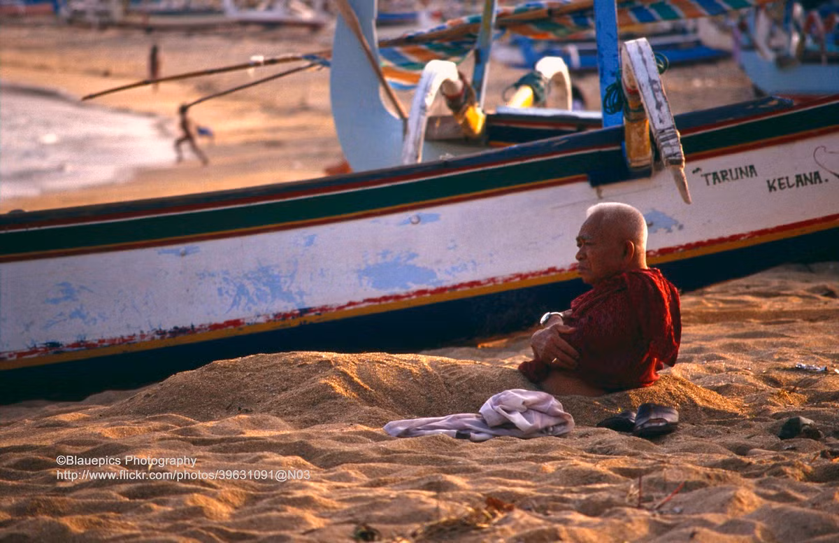 Cụ ông vùi mình trong cát.