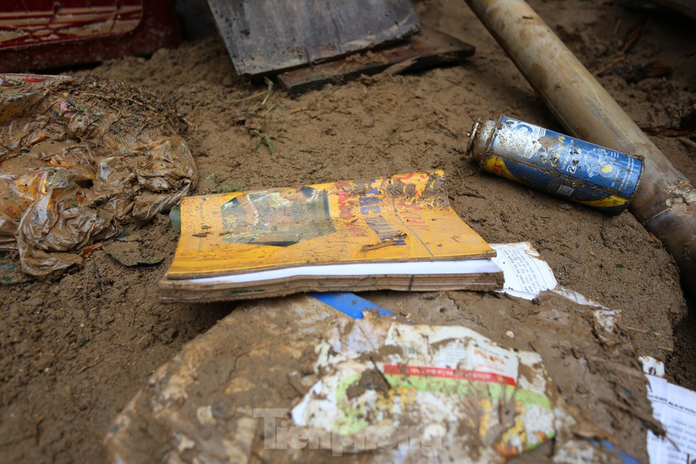 Giáo án, sách vở bị ngập trong lớp bùn đất dày hoặc ướt sũng do nước lũ.