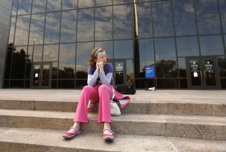 Cô bé Fay Wagstaff đến từ Texas buồn thiu ngồi trước thềm Viện Không gian và Nghệ thuật quốc gia Smithsonian đã bị đóng cửa.