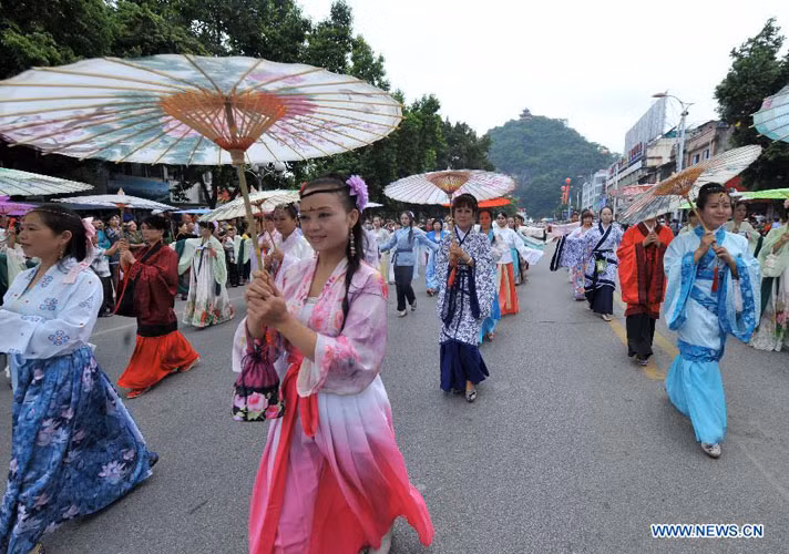 Các nữ nghệ sĩ chủ nhà trong bộ trang phục thướt tha diễu hành trên phố.