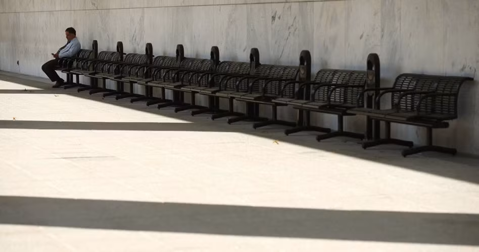 Một nhân viên hàng không ngồi một mình đơn độc ở cuối hàng ghế bên ngoài trụ sở Cơ quan hàng không Liên bang ở Washington.