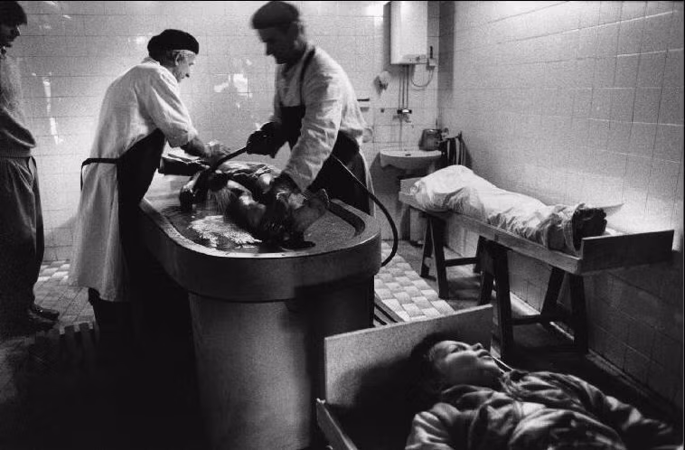 Thi thể một cậu bé đang được rửa trước khi đưa an táng tại một nhà tang lễ ở Sarajevo năm 1993. Cậu cùng hai bạn học và một giáo viên đã thiệt mạng khi ngôi trường của họ trúng đạn pháo. Ảnh: A. Abbas/ magnum Photos.