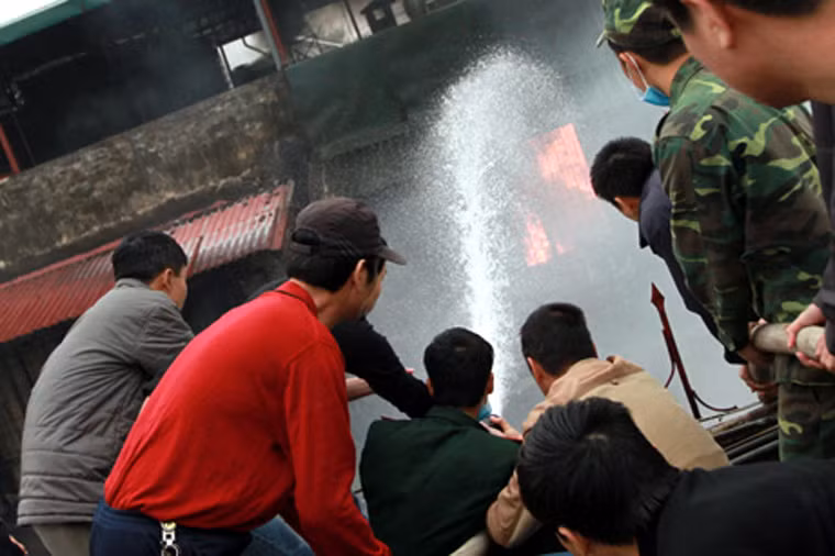 Người dân cùng các chiến sĩ bộ đội khẩn trương dập lửa.