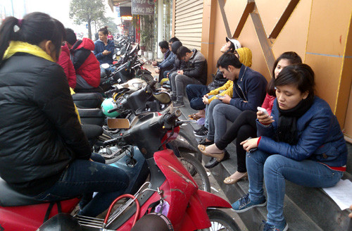 Dòng người ngồi vật vờ chờ mua vé xe về quê ăn Tết ở số 90 đường Trần Duy Hưng.