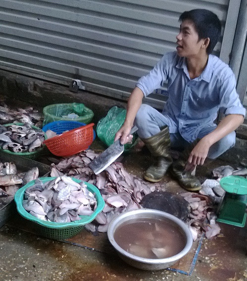 Các chủ hàng cá lọc ngay dưới nền đất và rửa đi rửa lại trong chậu nước đen ngòm.