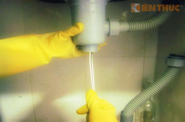  Sau đó, dùng sợi dây thép, lấy đi rác bẩn bám vào ống, thông đường nước chảy.