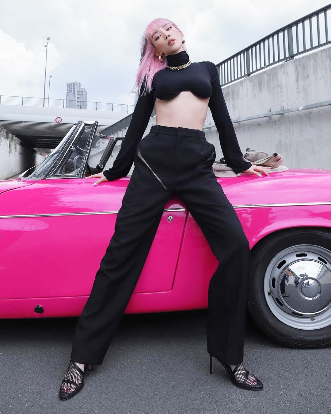 Tóc Tiên diện thiết kế tương đồng kiểu áo ở ảnh trên. Nữ ca sĩ lăng xê mốt tóc nhuộm hồng nhằm tạo độ tương phản với bộ trang phục đen cá tính. Ảnh: @toctien1305.