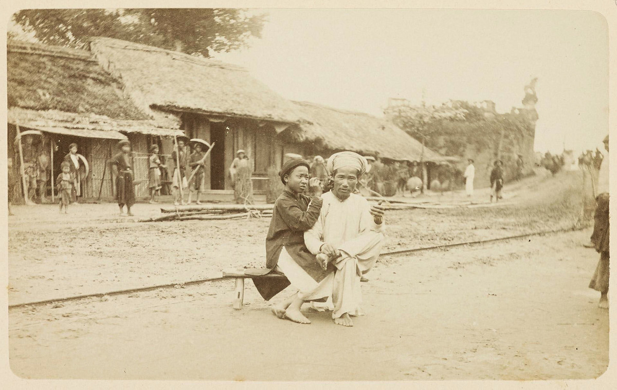 Thợ lấy ráy tai dạo trên phố Thợ Khảm (nay là phố Tràng Tiền), gần cổng Pháp Quốc, Hà Nội năm 1884-1885. Ảnh: Charles-Edouard Hocquard.
