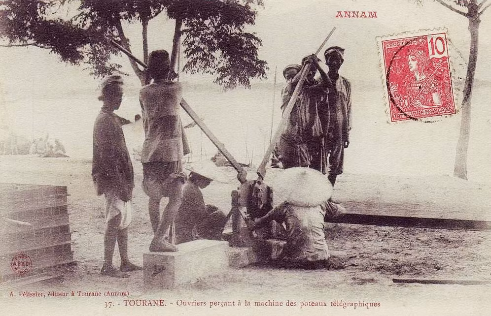 Công nhân đang đục lỗ trên các cột điện tín ở Đà Nẵng.