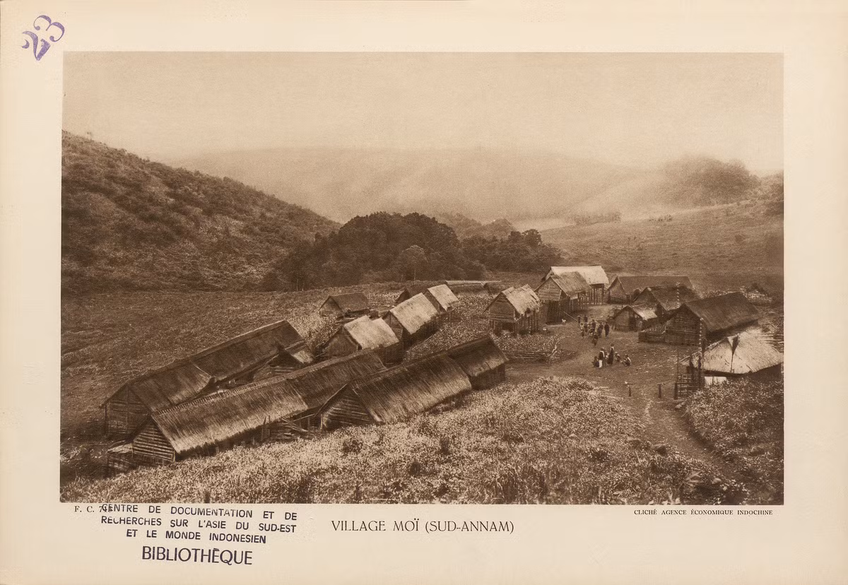 Bản làng của người Thượng ở miền Nam xứ Trung Kỳ. Những ngôi nhà dài được dựng kiểu nhà sàn, mái phủ cỏ rơm ở tiền cảnh là nơi sinh sống của một số gia đình. Những ngôi nhà nằm trên cọc cao ở phía xa là kho thóc.