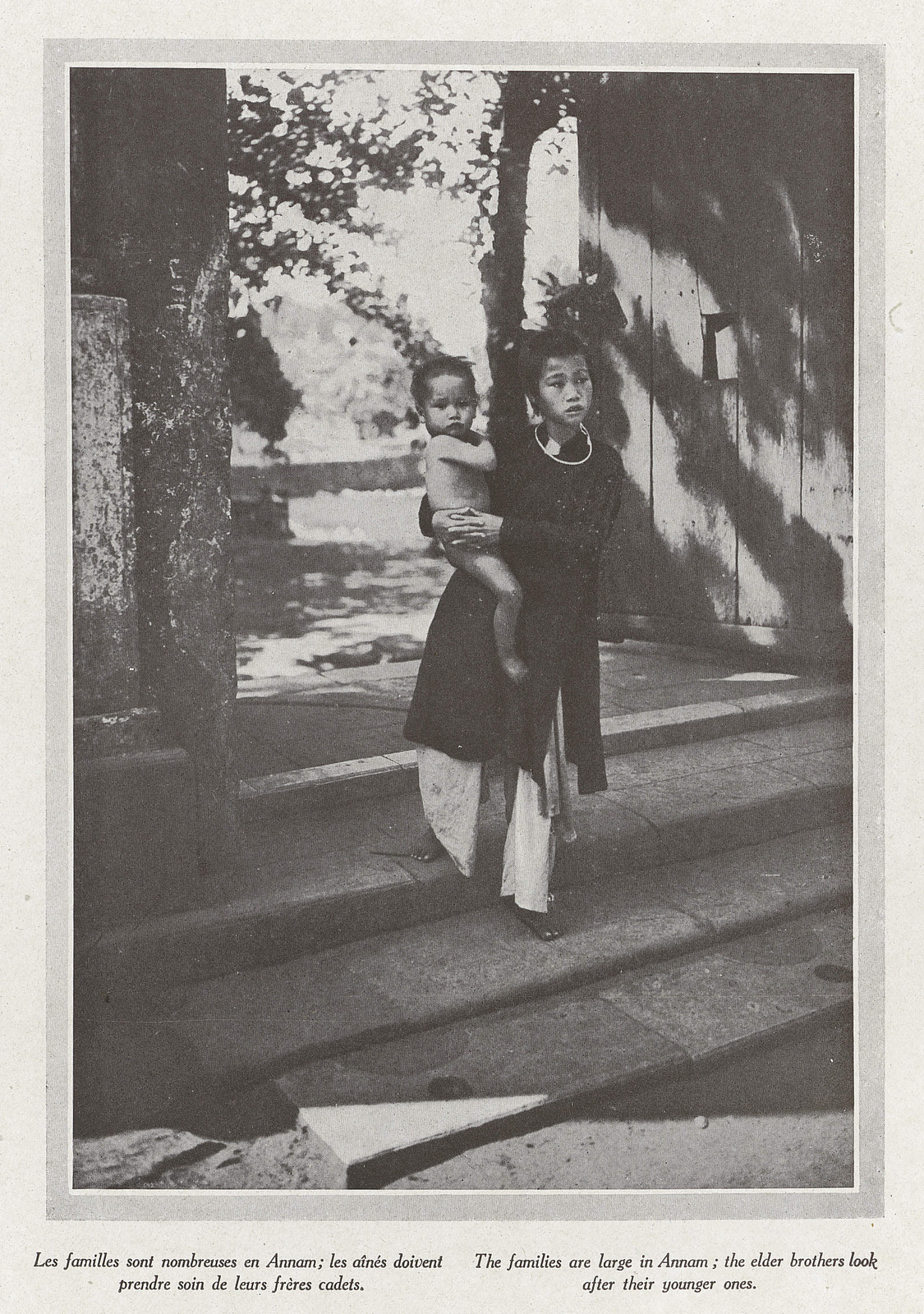 Hai chị em ngoài cổng một dinh thự.