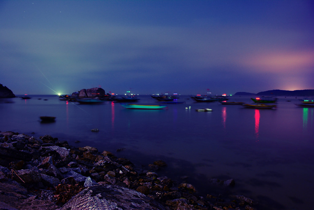Mặt biển lấp lánh ánh sáng từ những con thuyền.
