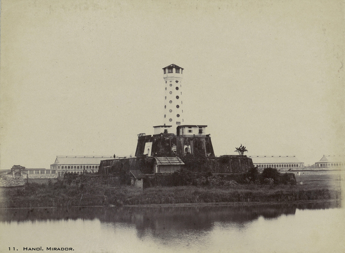 Cột cờ ở phía Nam thành Hà Nội năm 1899. Lúc này trước cột cờ có hào nước, trên cột cờ có chuồng bồ câu và một số gian nhà do người Pháp xây dựng. Sau cột cờ là khu doanh trại của quân đội Pháp.