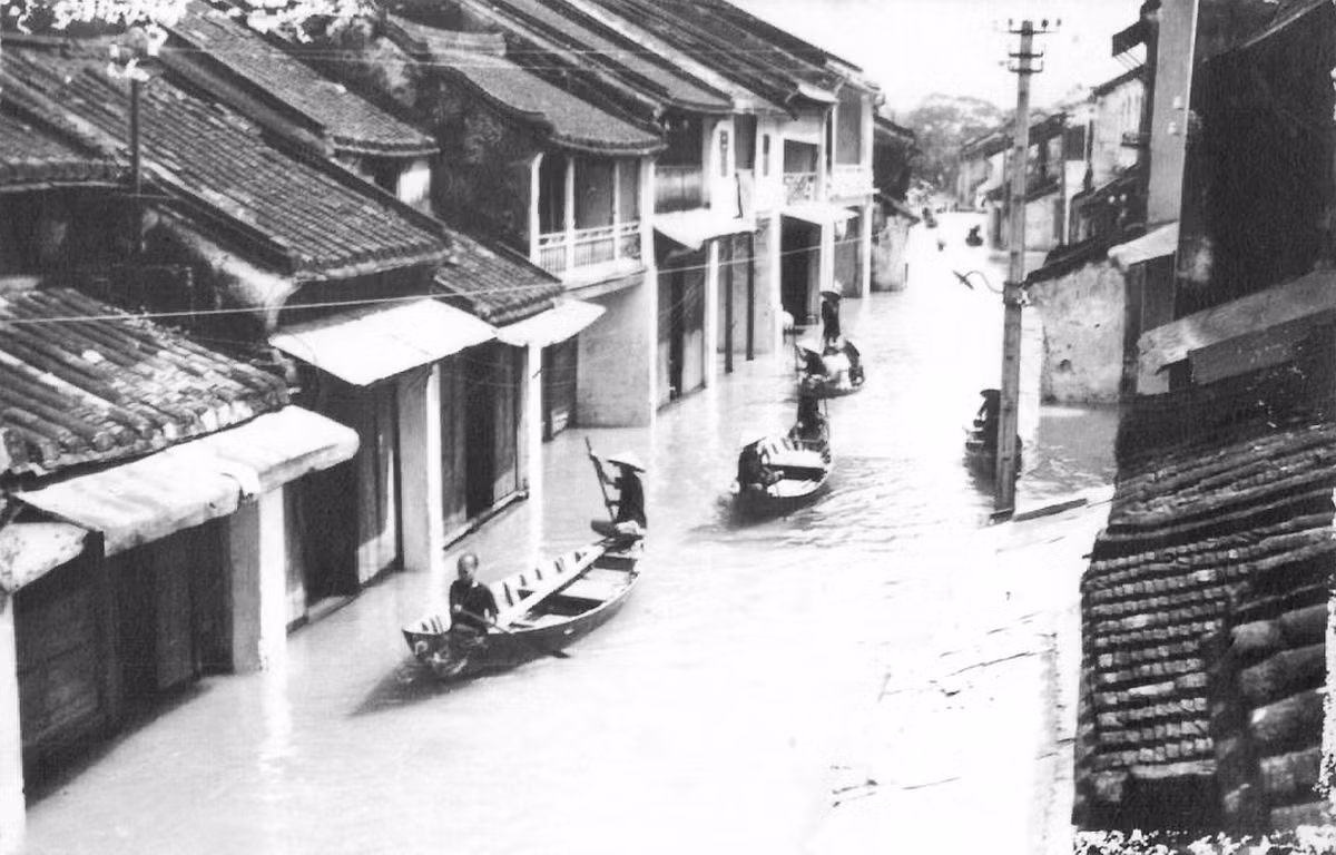 Người dân Hội An chèo thuyền trên những đường phố đã biến thành sông, 1964. Con số người chết được đưa ra trong trận lụt này là khoảng 6.000 người. Riêng tỉnh Quảng Nam có 2.500 người thiệt mạng, 22.447 nhà cửa bị hủy hoại. Ảnh: Hiệu ảnh Lệ Anh.