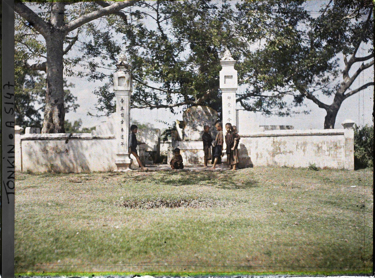 Đám trẻ con đứng trước cổng một khu lăng mộ.
