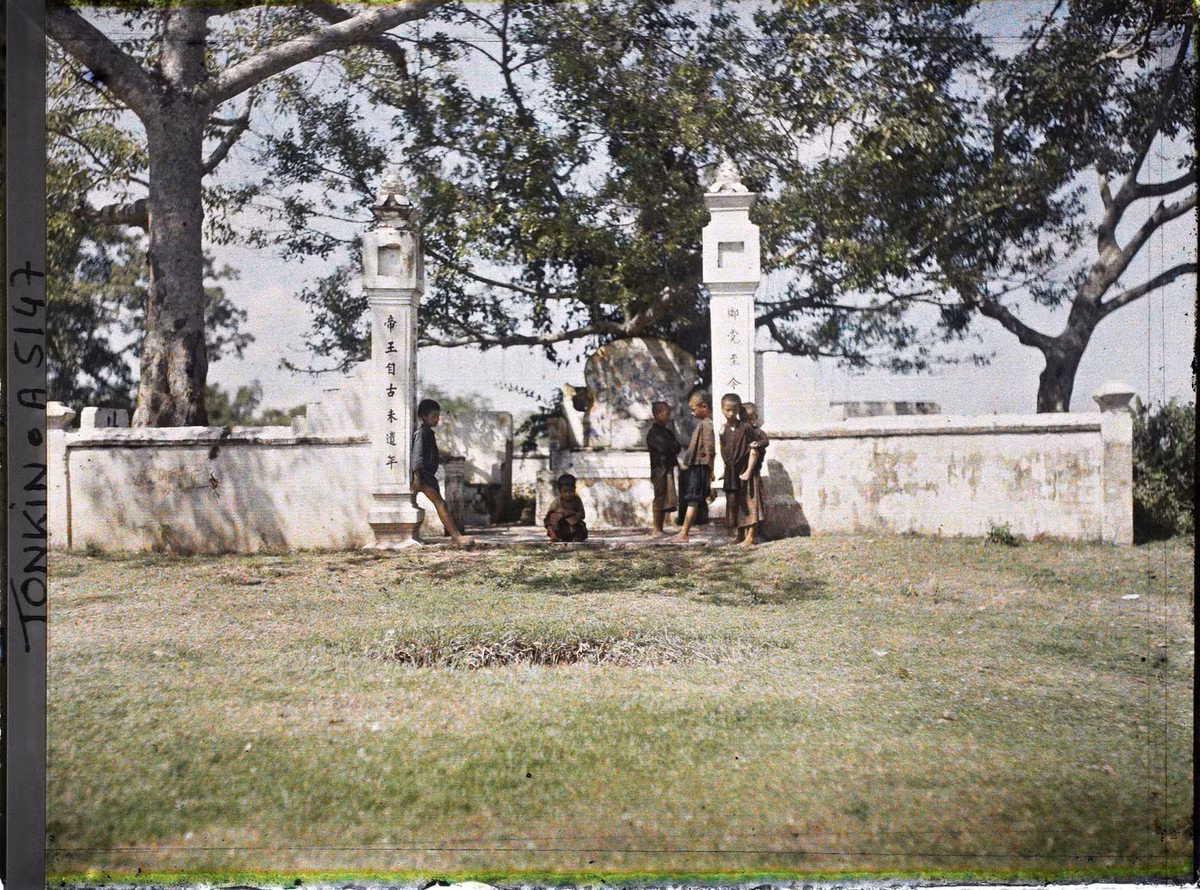 Đám trẻ con đứng trước cổng một khu lăng mộ.