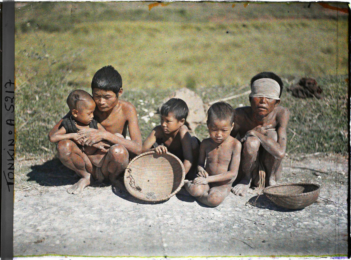Nam giới mù lòa và trẻ em ăn xin bên đường.