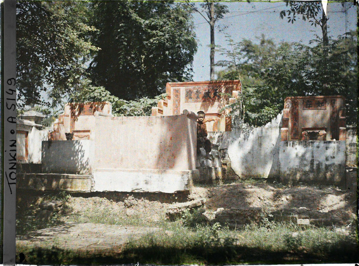 Cậu bé ngồi thơ thẩn ở khu lăng mộ bề thế.