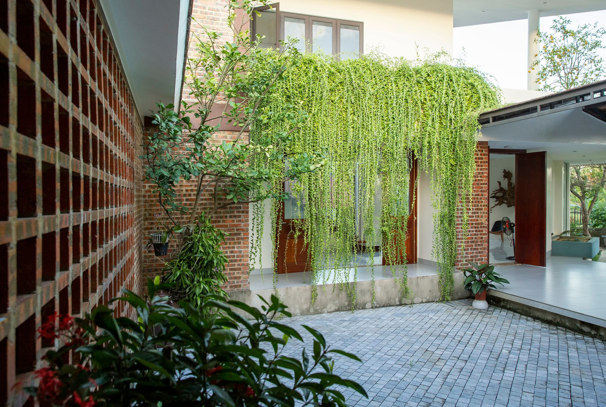 Khoảng sân trong này là phần trọng tâm của thiết kế, các khối chức năng được bố trí quây quần xung quanh tạo ra sự kết nối mà ở đó các thành viên trong gia đình giao tiếp hàng ngày. Với đặc trưng sinh hoạt ở quê, anh Sơn bố trí 2 không gian bếp. Phần không thể thiếu là khu vực bếp ướt phía sau, nơi chủ nhà có thể sơ chế thực phẩm tươi sống, nấu nướng đồ nặng mùi và quan trọng hơn dịp lễ, Tết, chủ nhà có thể dùng làm nơi lo việc mâm cỗ gia đình.