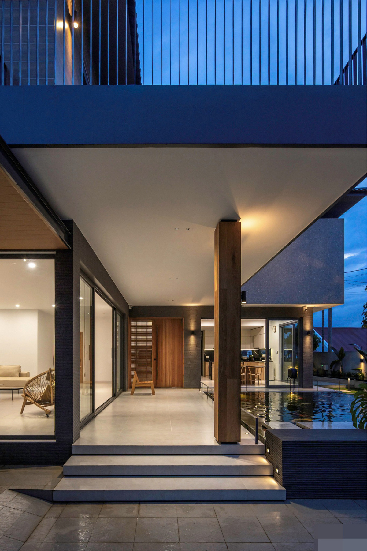 Gia chủ vốn yêu sự tinh giản gọn gàng, mỗi chi tiết của căn nhà đều được tính toán sao cho phải giản đơn nhưng đầy tính kỹ thuật. Chi tiết bậc thềm tam cấp được ốp bằng gạch men để đảm bảo tính đồng bộ với sàn. Cột bê tông được ốp gỗ sồi tự nhiên sau gần 2 năm sử dụng có phảng phất màu thời gian.