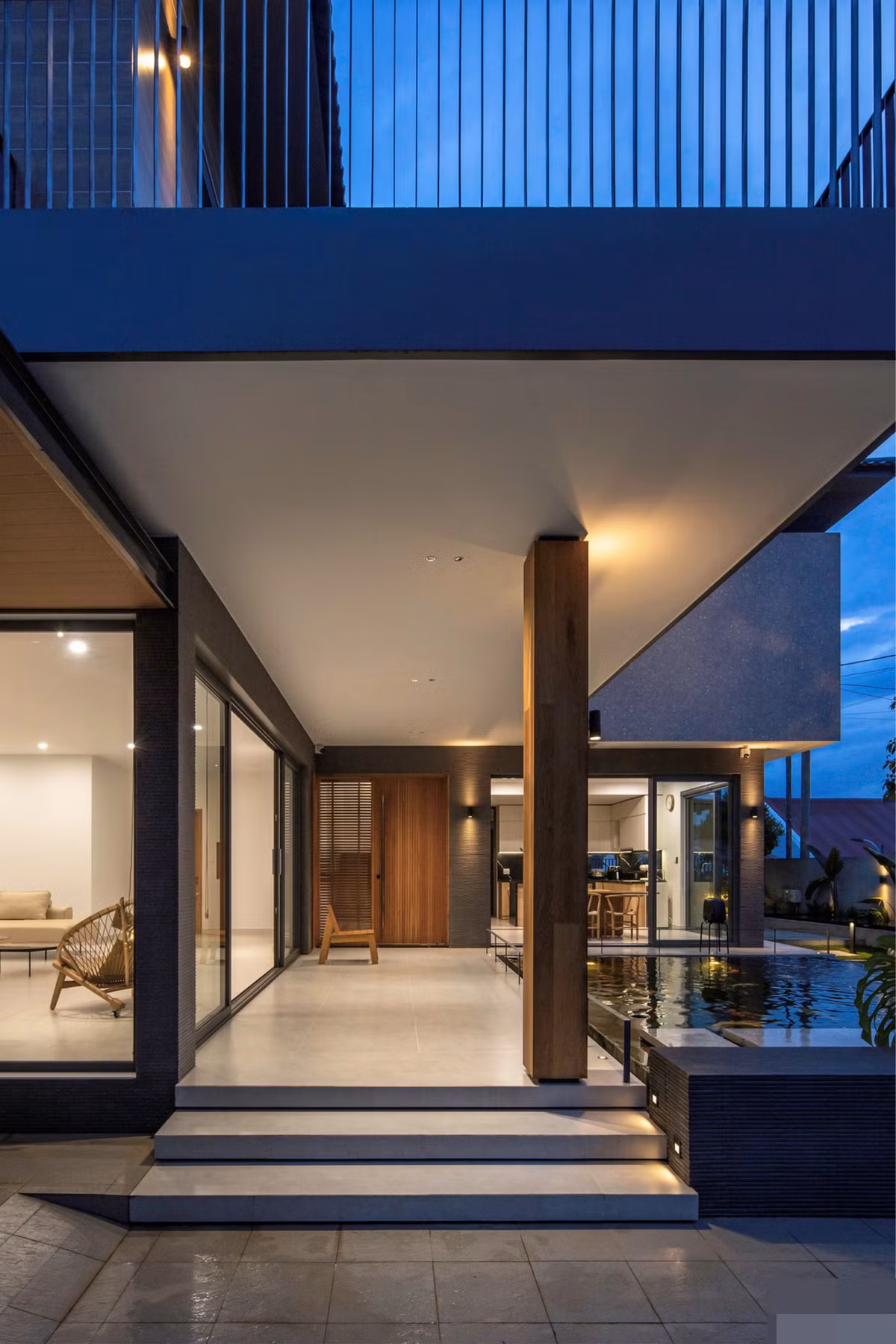 Gia chủ vốn yêu sự tinh giản gọn gàng, mỗi chi tiết của căn nhà đều được tính toán sao cho phải giản đơn nhưng đầy tính kỹ thuật. Chi tiết bậc thềm tam cấp được ốp bằng gạch men để đảm bảo tính đồng bộ với sàn. Cột bê tông được ốp gỗ sồi tự nhiên sau gần 2 năm sử dụng có phảng phất màu thời gian.