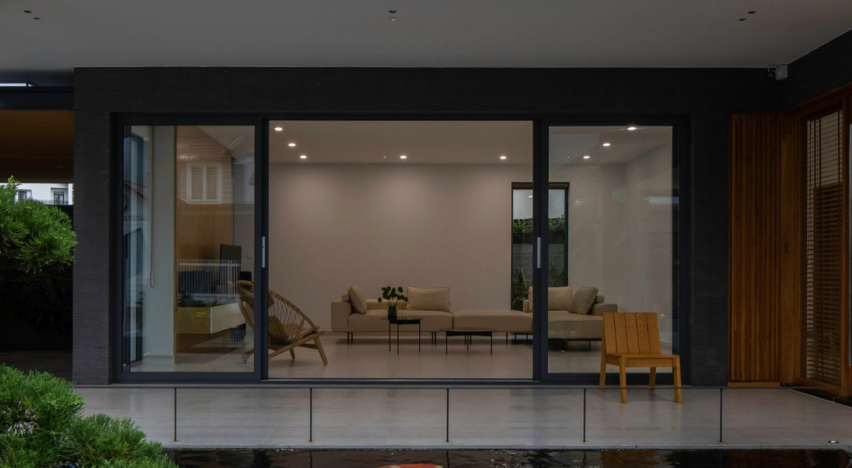 Tâm điểm phòng khách của căn nhà là khung cửa tỷ lệ 21:9, bằng tỷ lệ rạp chếu phim với mong muốn các thành viên ngắm nhìn khung cảnh được chuyển tiếp sớm hôm, bốn mùa Xuân- Hạ- Thu- Đông như một bộ phim cuộc đời, dậy sớm đun ấm trà cùng với ông nội thưởng thức buổi sáng bình yên, chiều về thủ thỉ với con những chuyện đi học ở trường, buổi tối vợ chồng dùng một chút vang nhẹ chia sẻ đôi ba câu chuyện tâm tình, giản đơn mà hạnh phúc.