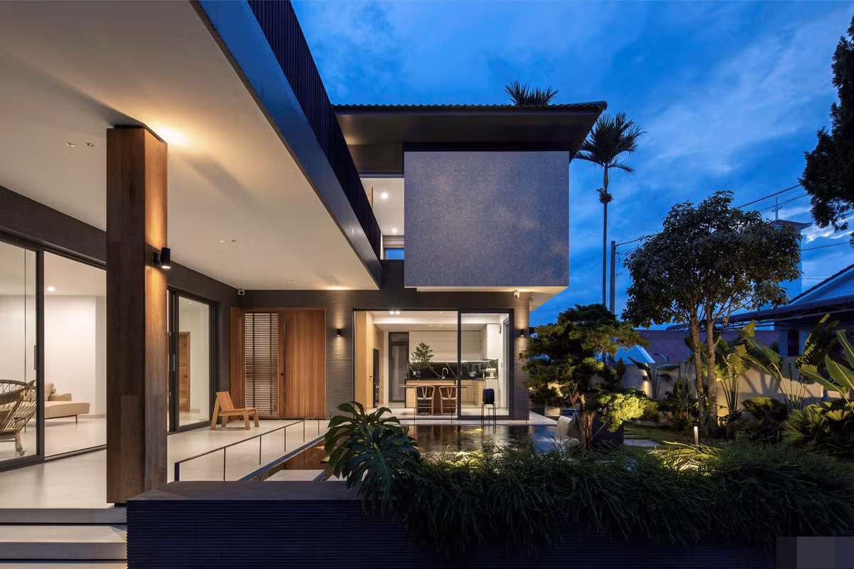 Căn nhà có dạng chữ L, 2 cánh nhà vươn ra với nhiều cửa kính lùa, vừa giúp tối ưu thông gió và chiếu sáng tự nhiên, vừa phù hợp với thói quen sinh hoạt trong các không gian chung của gia đình truyền thống.