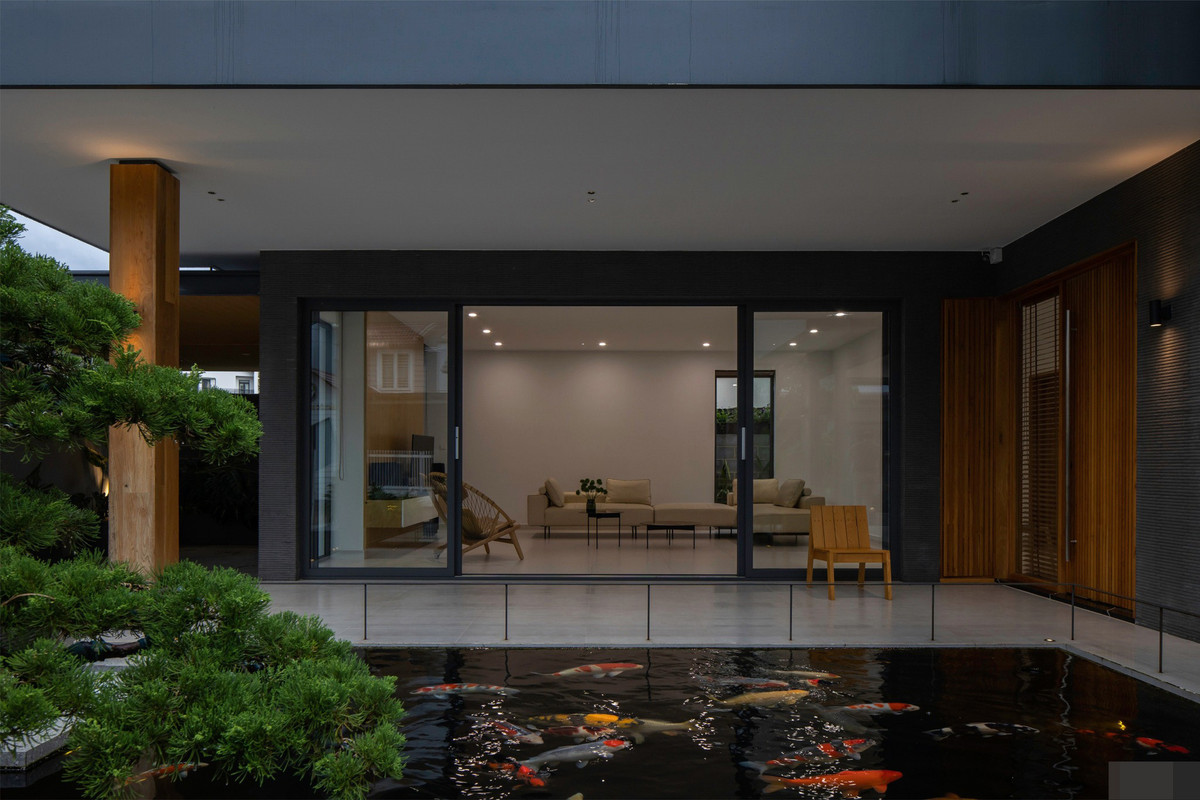 Mái sảnh hay mái hiên vốn là không gian đa năng của người Việt, là nơi đón ta về, là nơi mở cửa, là nơi thay giầy, là nơi ngồi đón cơn gió mát mẻ đầu mùa, là nơi trẻ con chơi đùa, là nơi người lớn trải chiếu khi có cỗ hay là nơi pha ấm trà mở đầu câu chuyện hàn huyên… Xung quanh hồ Koi có bố trí hệ lan can thép mảnh để giới hạn không gian. Vừa đủ chiều cao an toàn cho trẻ em mà không ảnh hưởng đến góc ngắm cá từ trong nhà nhìn ra.