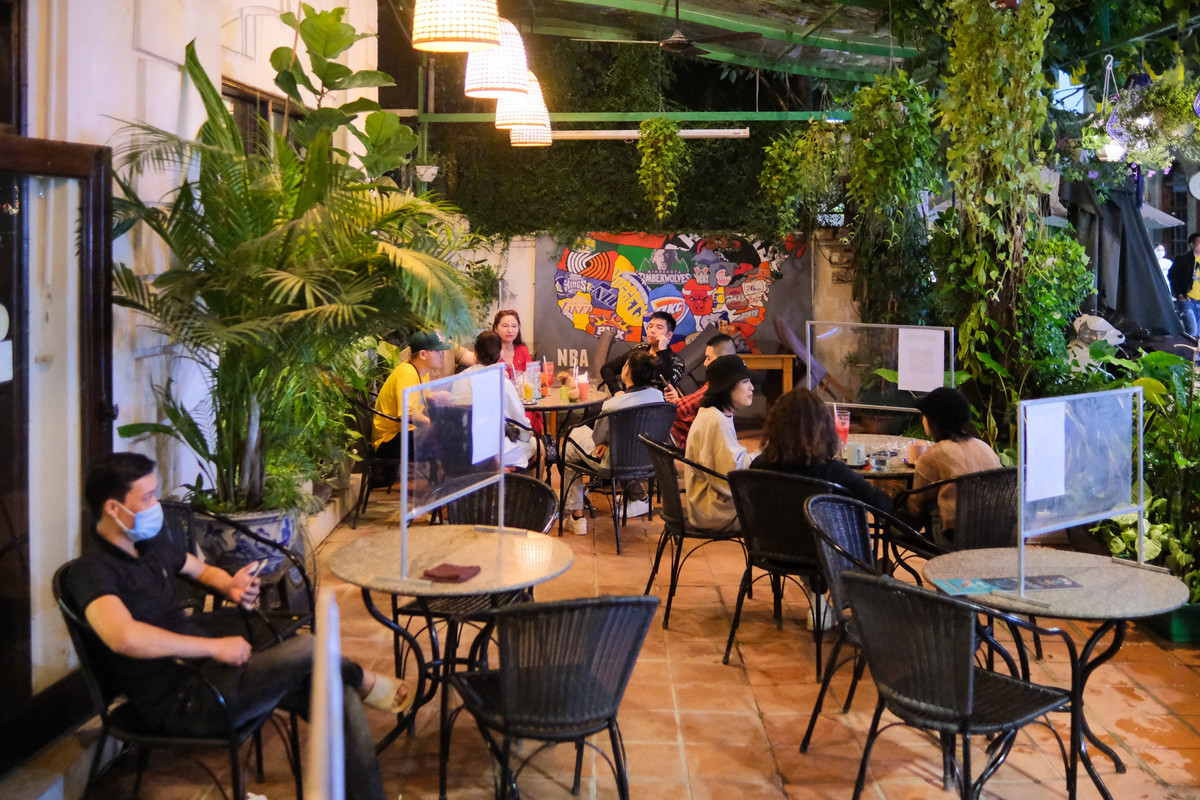 Các tấm vách ngăn được dựng lên ở mỗi bàn để đảm bảo giãn cách. Nhân viên phục vụ bắt buộc phải đeo khẩu trang trong lúc tiếp xúc khách hàng.