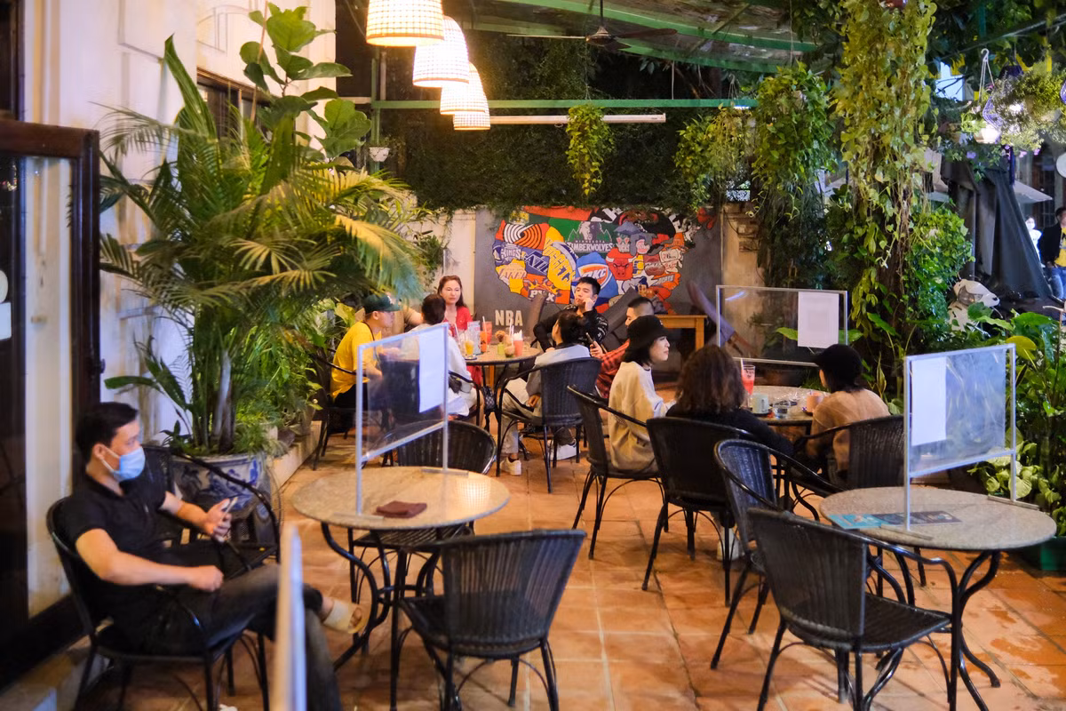 Các tấm vách ngăn được dựng lên ở mỗi bàn để đảm bảo giãn cách. Nhân viên phục vụ bắt buộc phải đeo khẩu trang trong lúc tiếp xúc khách hàng.