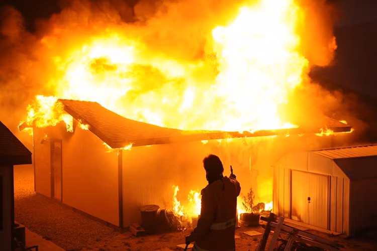 Nhà quay phim truyền hình Shawn Kaye bỏ camera cầm vòi phun nước tham gia chữa cháy ở gần Banning, ngày 7/8/2013.