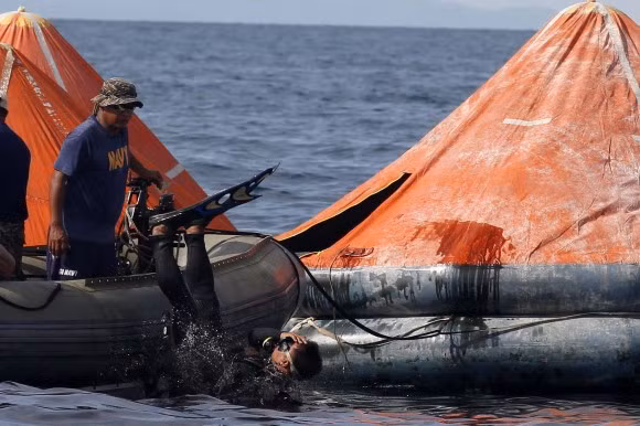 Thợ lặn tìm kiếm những người bị chìm xuống biển.