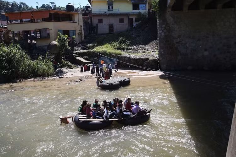 Họ vượt sông trên những "con thuyền" vá víu ngay dưới chân cầu để trốn trạm kiểm soát ở ngay trên đầu cầu.