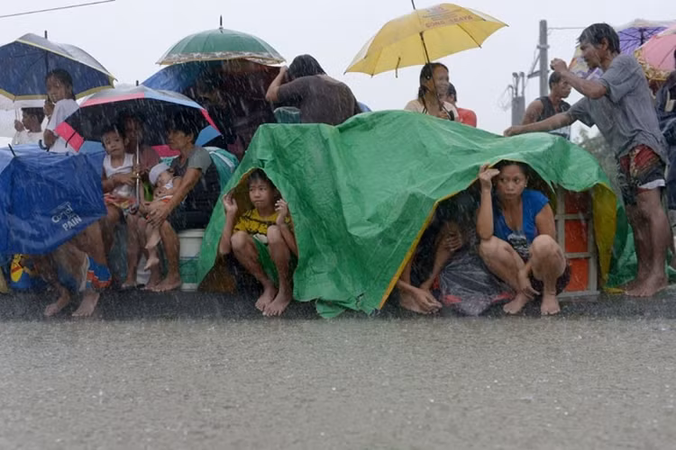 Tình cảnh bi đát của những người dân phải rời bỏ nhà cửa và phải dầm mình trong mưa ở những nơi vẫn còn chưa bị ngập nước.