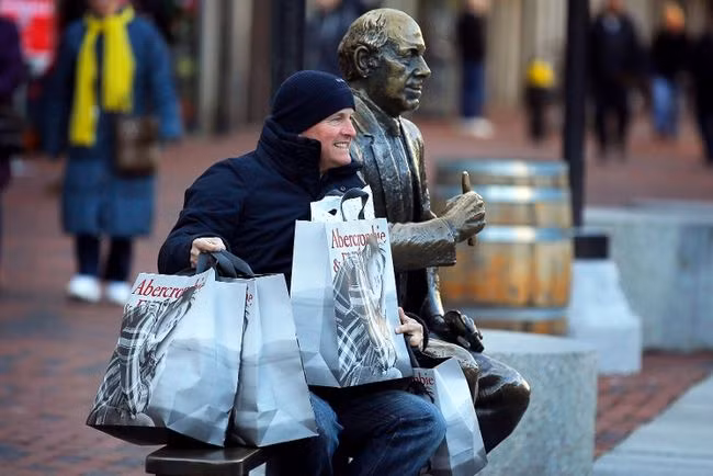 Dù kiệt sức nhưng một người đàn ông vẫn hồ hởi vì mua được nhiều hàng giảm giá.