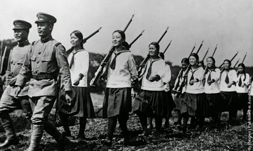 Một nhóm nữ học sinh Nhật Bản di chuyển theo đội hình chỉnh tề khi đến thăm một đơn vị quân đội để tìm hiểu cuộc sống của người lính. Ảnh chụp năm 1938.