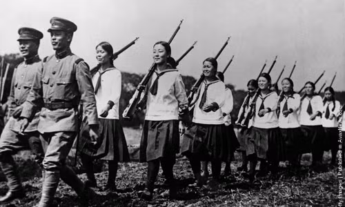 Một nhóm nữ học sinh Nhật Bản di chuyển theo đội hình chỉnh tề khi đến thăm một đơn vị quân đội để tìm hiểu cuộc sống của người lính. Ảnh chụp năm 1938.