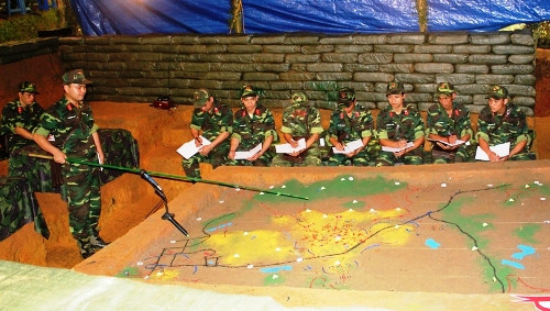 Đại đội trưởng đại đội bàn cách đánh trên sa bàn.