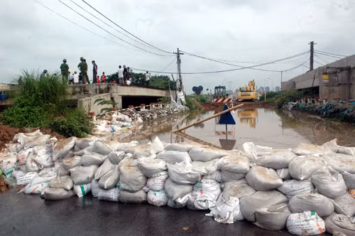 Những bao tải đất ngăn dòng nước tràn vào khu dân cư.