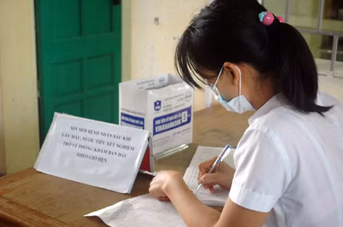 Y tá vào sổ xét nghiệm cho bệnh nhân.