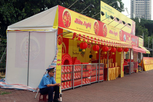 Thanh tra giao thông ngồi cạnh quầy bán bánh trung thu trên đường Phạm Văn Đồng, cạnh trường ĐH Ngoại ngữ, quận Cầu Giấy.