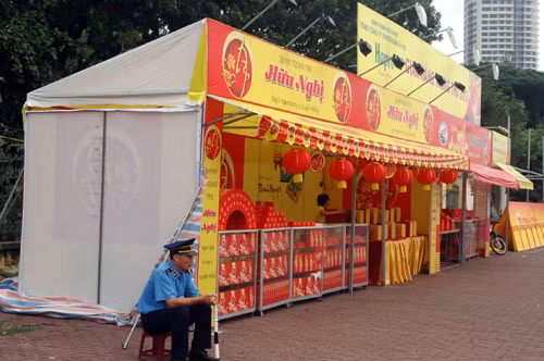 Thanh tra giao thông ngồi cạnh quầy bán bánh trung thu trên đường Phạm Văn Đồng, cạnh trường ĐH Ngoại ngữ, quận Cầu Giấy.