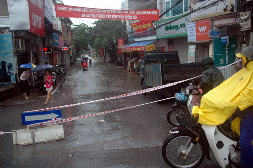 Chịu ảnh hưởng của cơn bão số 6, mưa lớn kéo dài khiến nhiều tuyến phố Hà Nội ngập nặng. Nước ngập tràn vào nhà dân, các phương tiện lưu thông gặp nhiều khó khăn. Trong ảnh là cảnh chăng dây báo hiệu cấm các phương tiện đi vào "sông" trên phố Trần Bình.