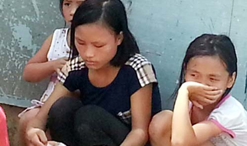 Quỳnh Anh (áo đen ở giữa) cùng 2 cháu bé ngồi bên đường.