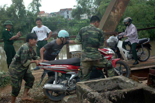 Các chiến sĩ bộ đội giúp dân qua đường.