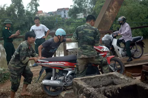 Các chiến sĩ bộ đội giúp dân qua đường.