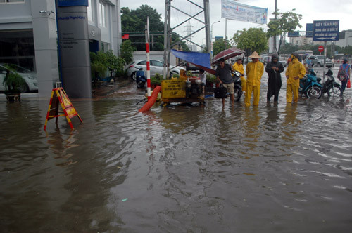 Công nhân Công ty thoát nước Hà Nội túc trực trên phố Trần Quốc Hoàn...