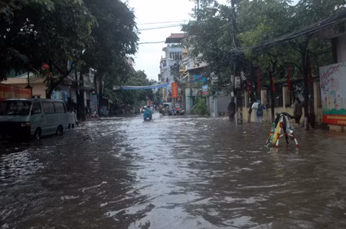 Phố Trần Bình thành sông, ô tô phải chạy dạt vào một bên.